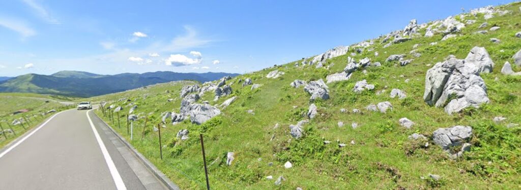四国カルストの石灰岩が点在する草原とドライブ道