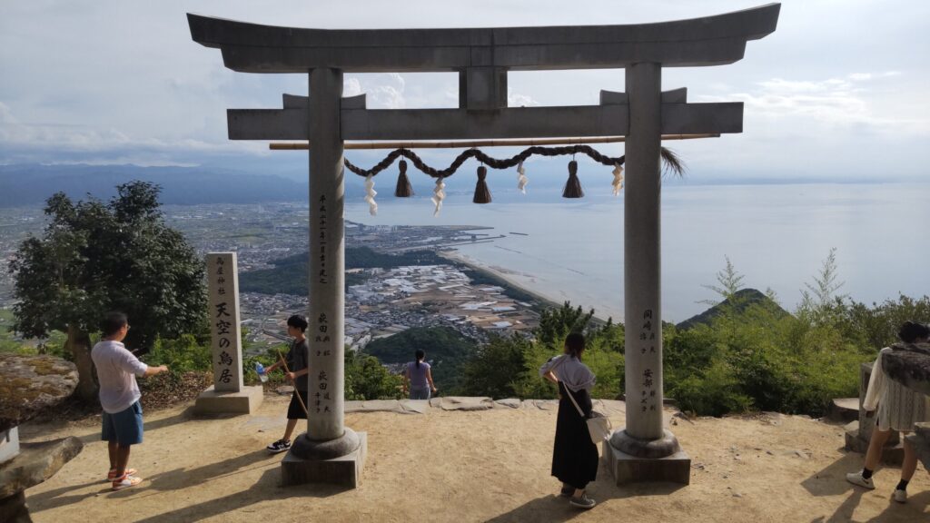 高屋神社の鳥居と展望スポットに集まる参拝客