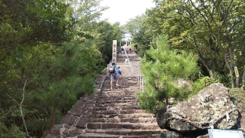 高屋神社へ続く長い石段を上る参拝者たち
