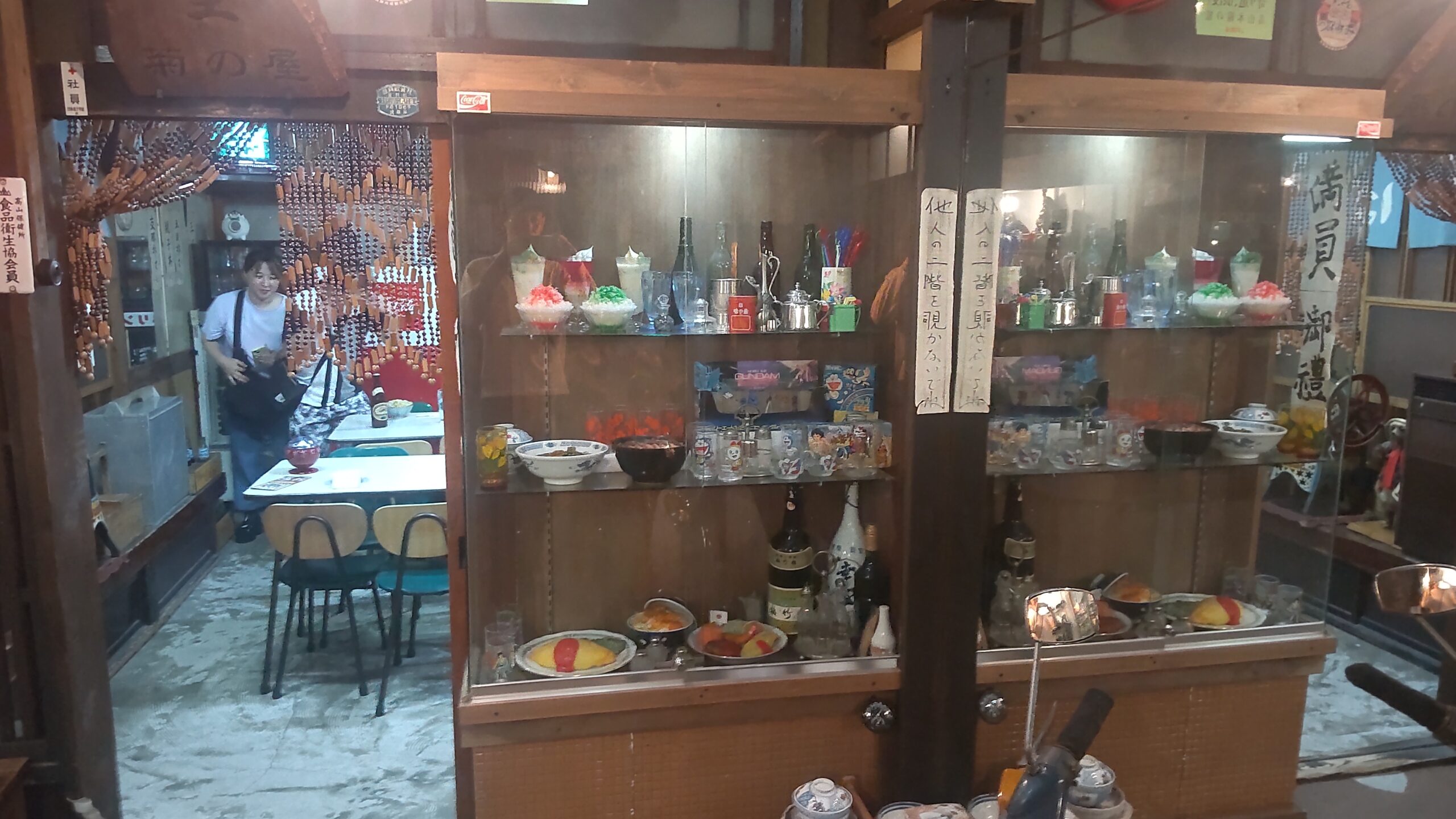 ガラスケースに陳列された昭和の食品サンプルと食器