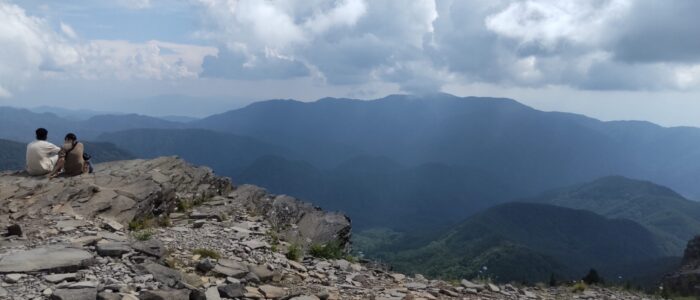 山頂からの絶景を眺めるカップル